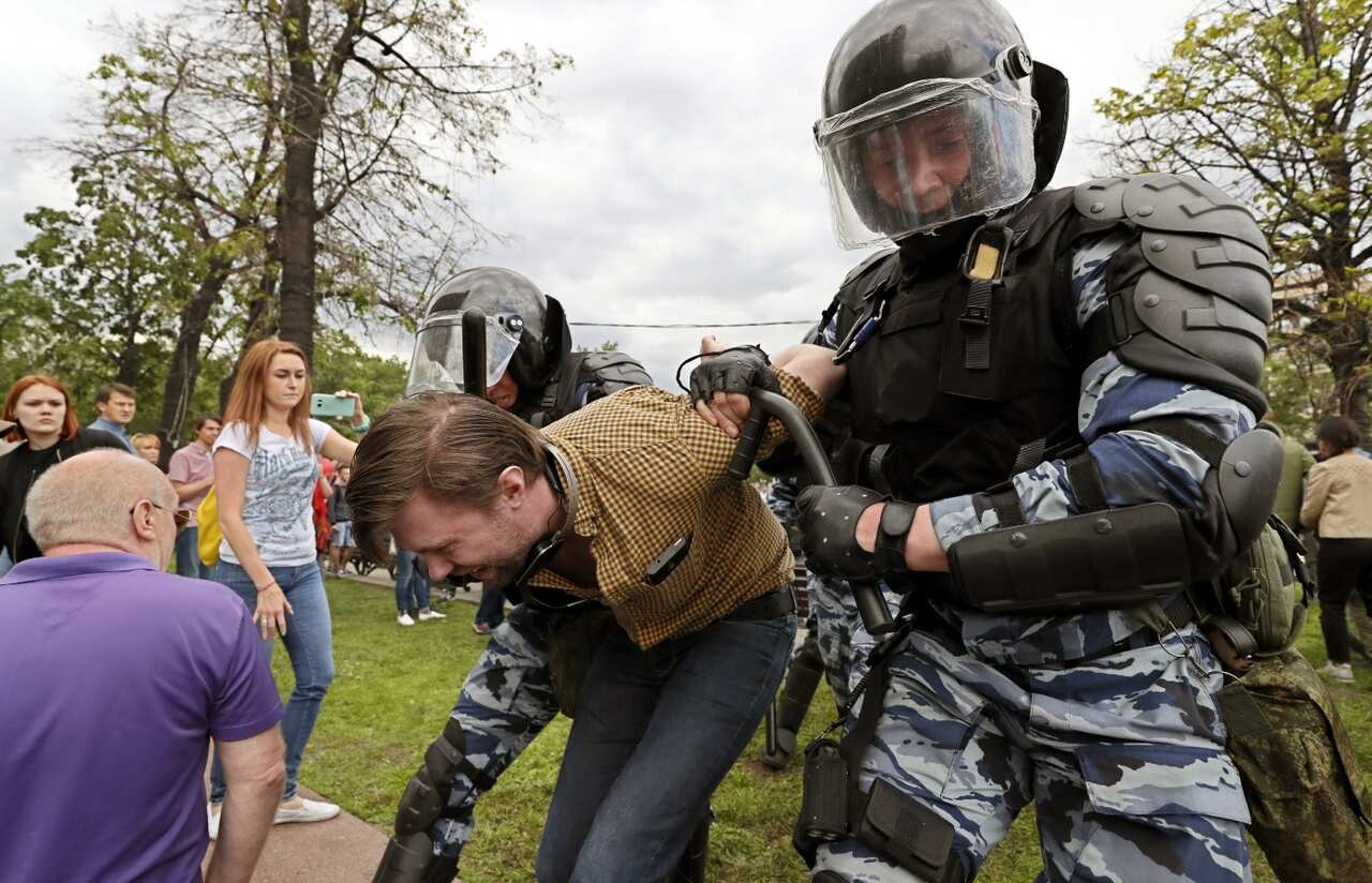 Russian police officers detain a participant of an unauthorized opposition rally in Tverskaya street in central Moscow, Russia, on Russia Day (AAP)