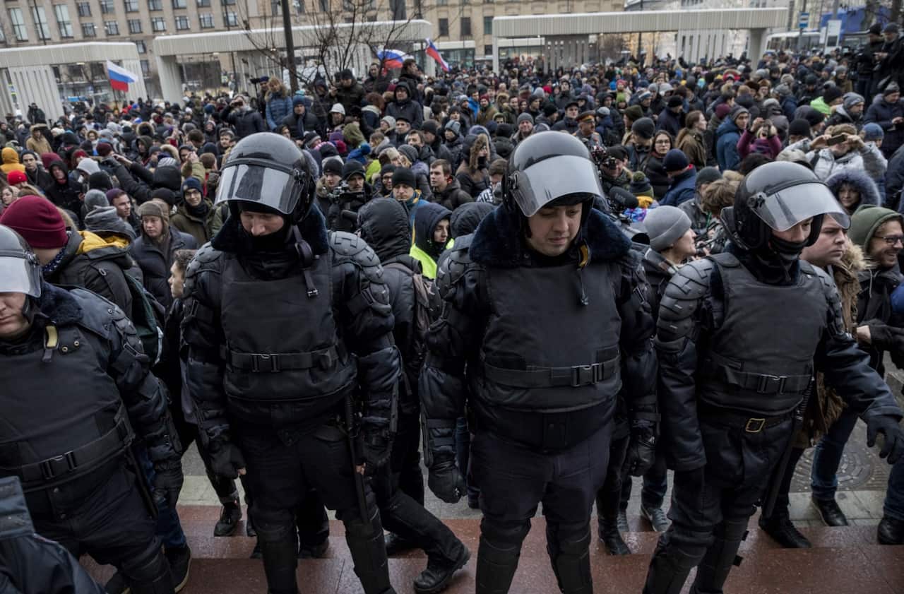 Russia, Moscow:Policemen stand guard as supporters of opposition leader Alexei Navalny hold sign-boards during a rally in Pushkin Square in Moscow on January 28,