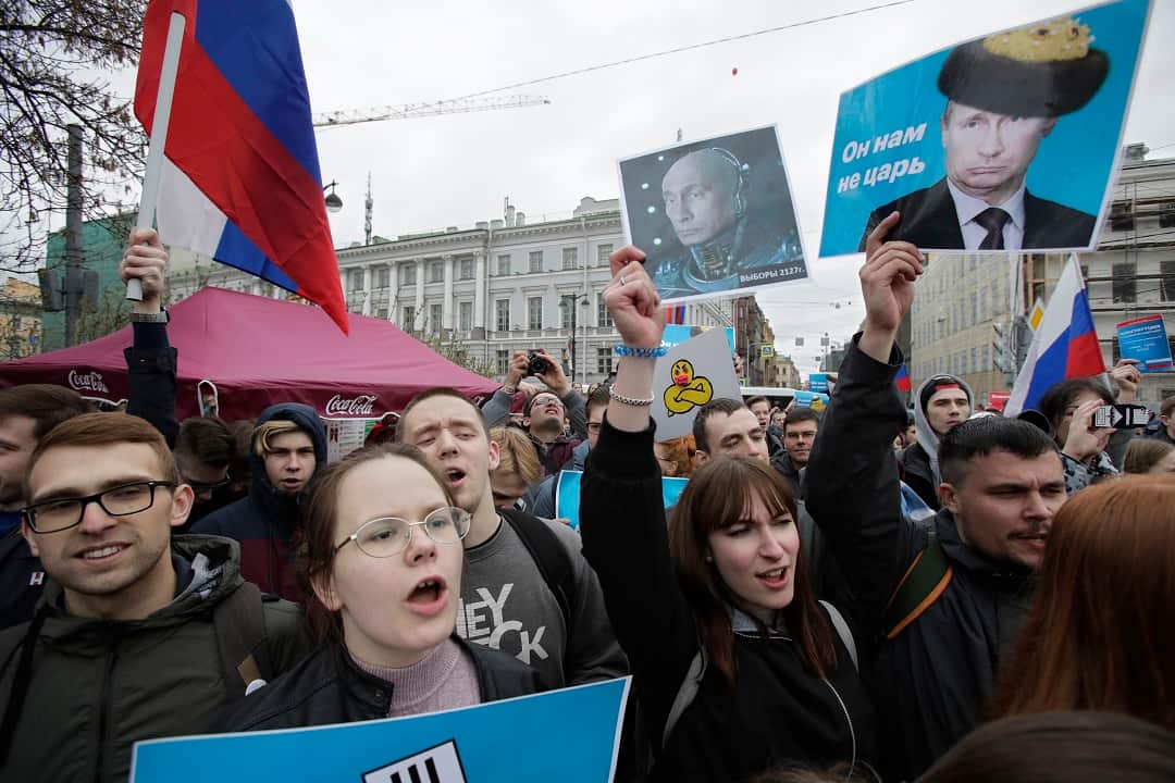 Demonstrators carry posters depicting Russian President Vladimir Putin during a massive protest rally in St Petersburg, Russia.