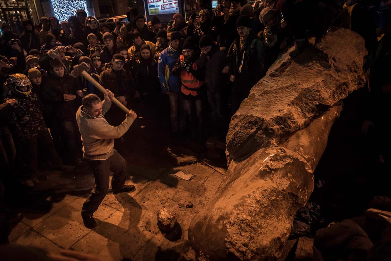 Protesters break apart a statue of Lenin after it was pulled down in Kyiv, Ukraine, Dec. 8, 2013. 