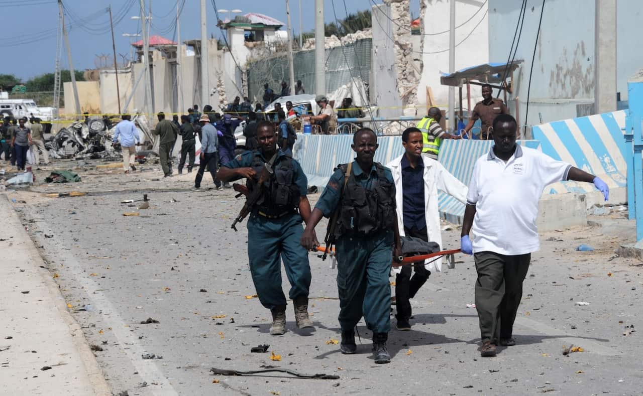 United Nations Mogadishu office staff and Somali soldiers carry the body of a colleague on a stretcher (Getty)