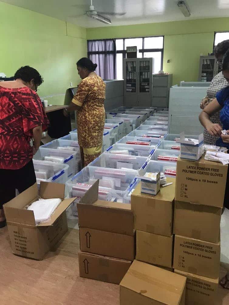 Health workers preparing vaccination packages ready for mobile distribution.
