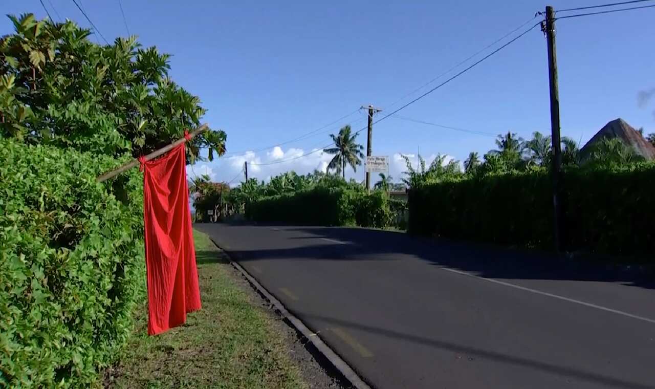 Red flags hangs outside homes of residents who have not been vaccinated in Apia, Samoa.