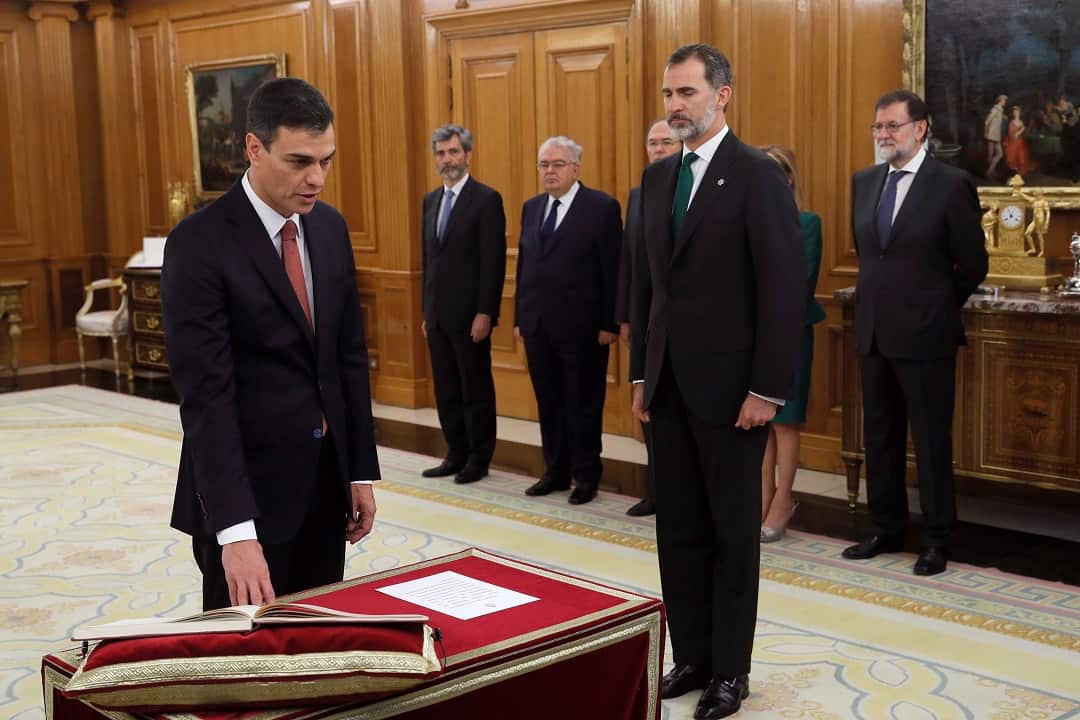 New Spanish PM Pedro Sanchez is sworn in as the man he ousted Mariano Rajoy (R) watches on.