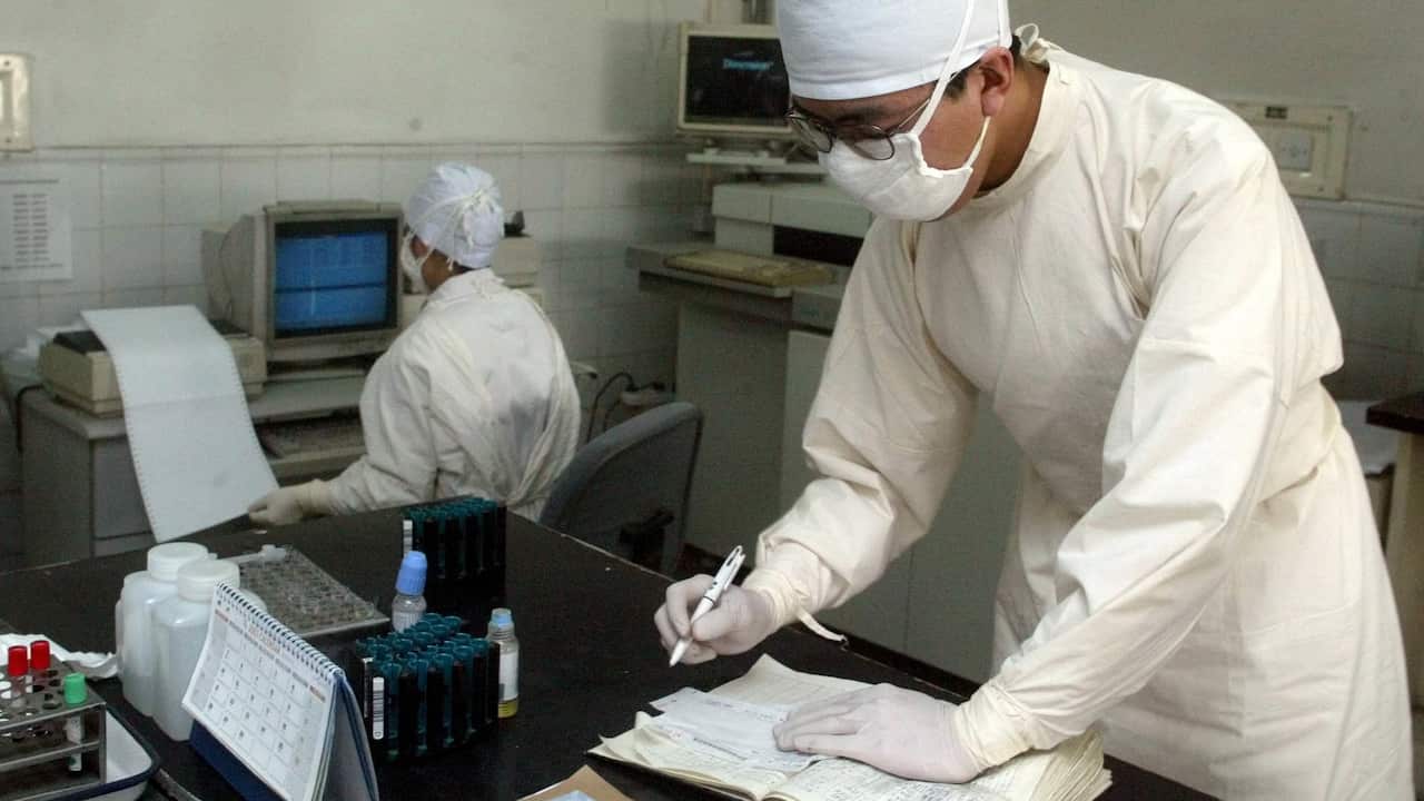 Masked medical staffs analyze semen and blood samples at the Beijing Ditan Hospital in Beijing.
