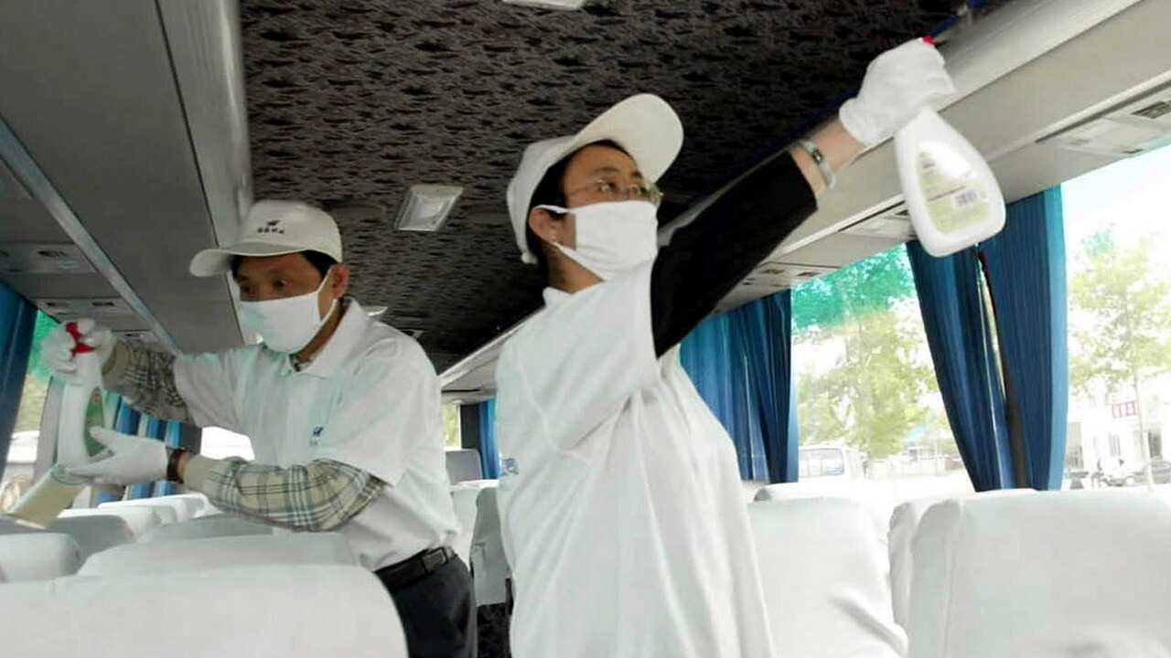 Employees of Beijing Capital Taxi Co spray disinfectant over their traveling coaches in Beijing in 2003, amid the SARS outbreak.
