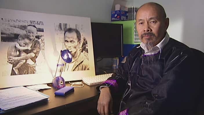 Malcolm Vu with photos of his parents in Laos