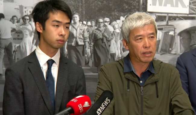 Migrant worker Xueliang Wang (r) speaks to media.