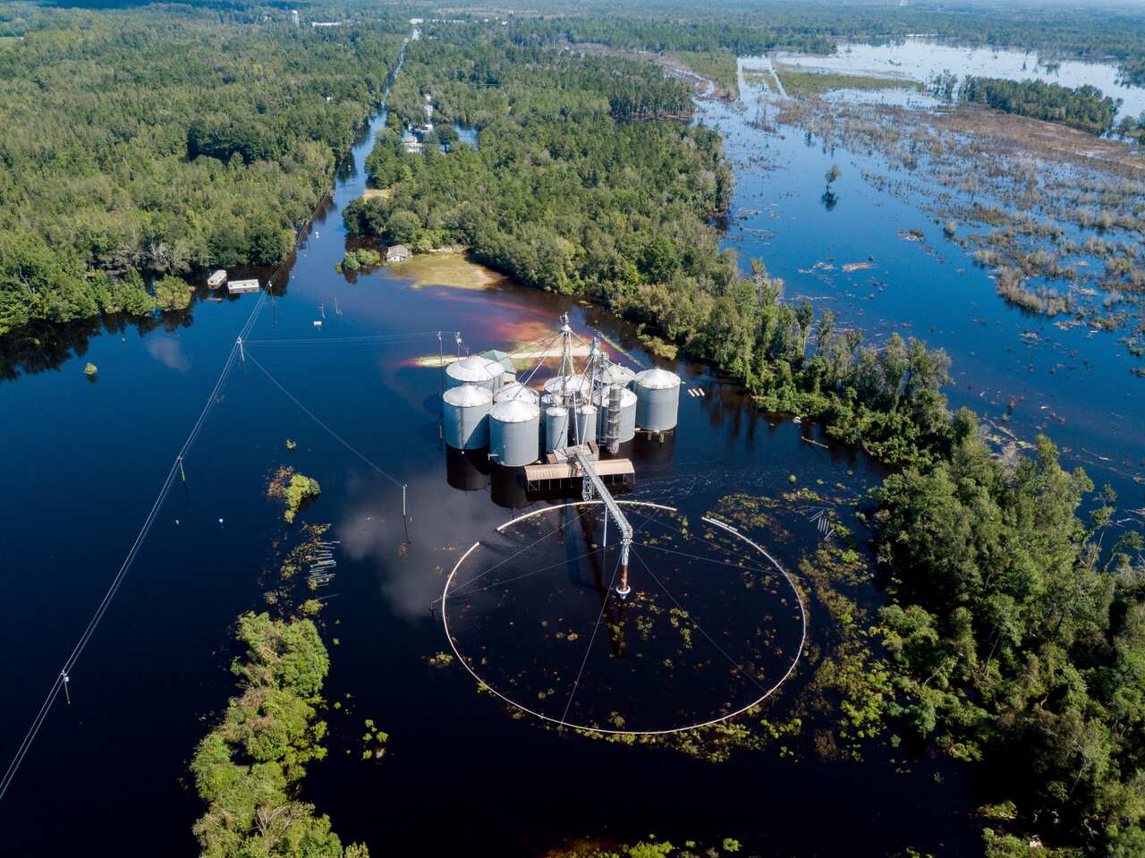 A flooded grain business along Highway 76, which follows the power lines at left, where law enforcement were searching for a submerged van near Nichols, S.C.,