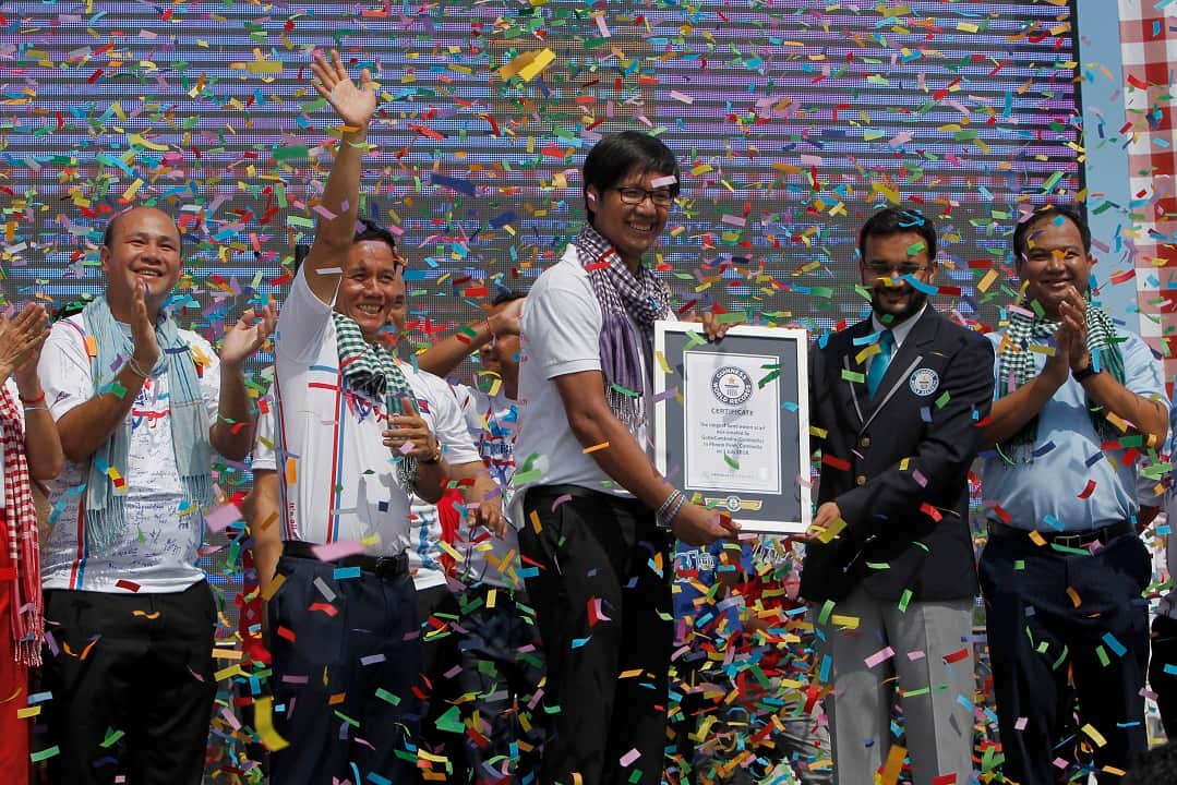 An adjudicator presents a certificate to Sann Vathana of the GoGo Cambodia movement.
