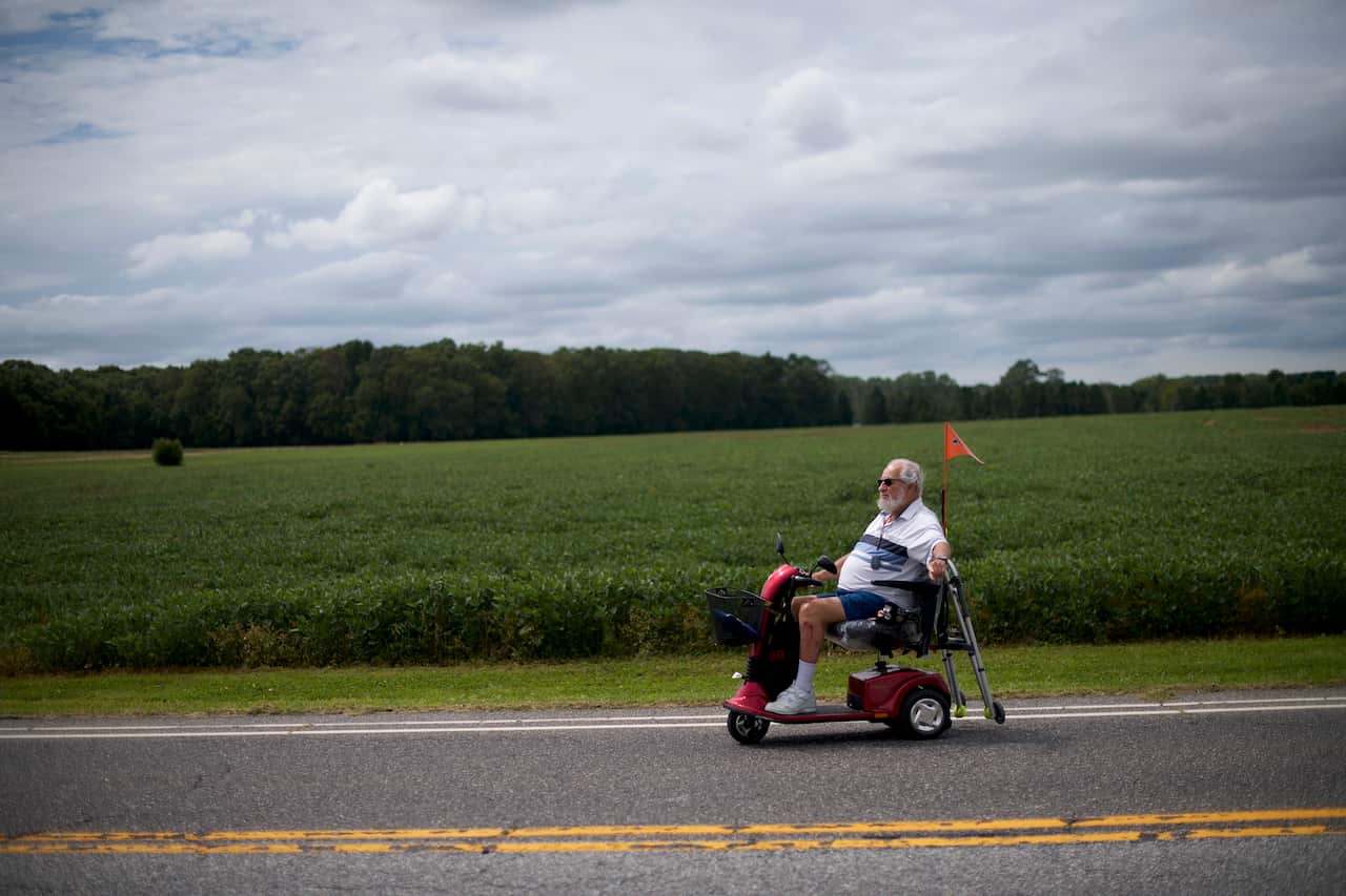 Carl Abrams, 90, a retired Air Force Colonel, signals while turning left as he rides his scooter in Williamstown, N.J. on Aug. 28, 2019. (Mark Makela/The New York Times)
