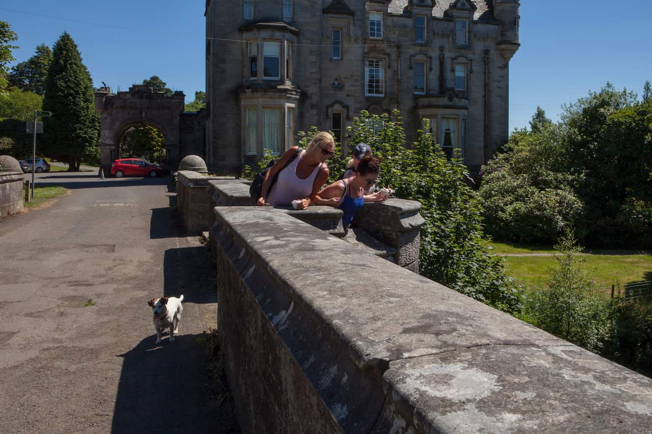 People with a dog on Overtoun Bridge in Dumbarton, Scotland.