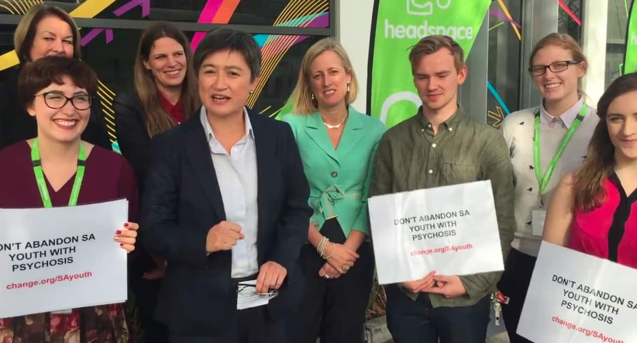 Penny Wong stands with a group of smiling supporters.