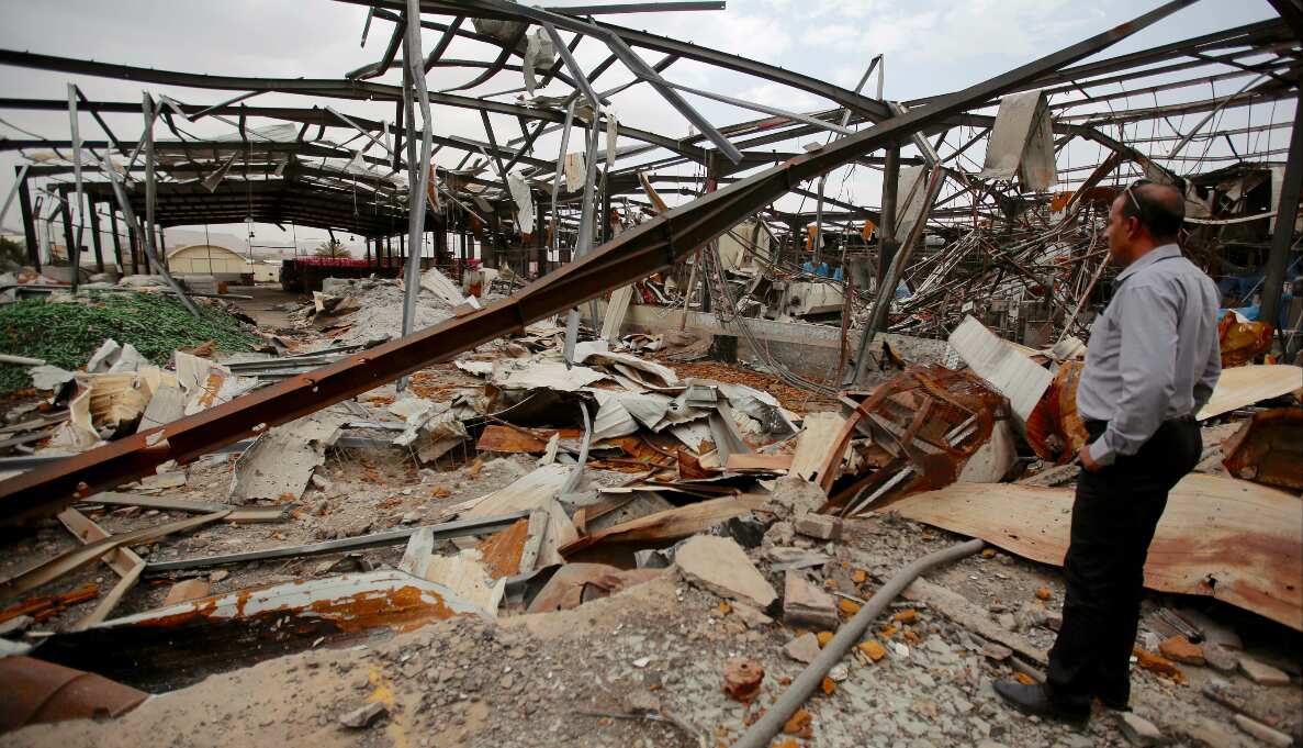 A worker stands on the rubble of a Coca-Cola beverages factory after Saudi-led air strikes destroyed it 