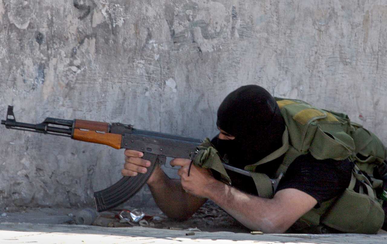 A member of the security force of the Hamas-led government exchanges fire during a shootout with Palestinian police loyal to Palestinian President Mahmoud Abbas in Gaza City in this photo taken Monday, May 22, 2006.