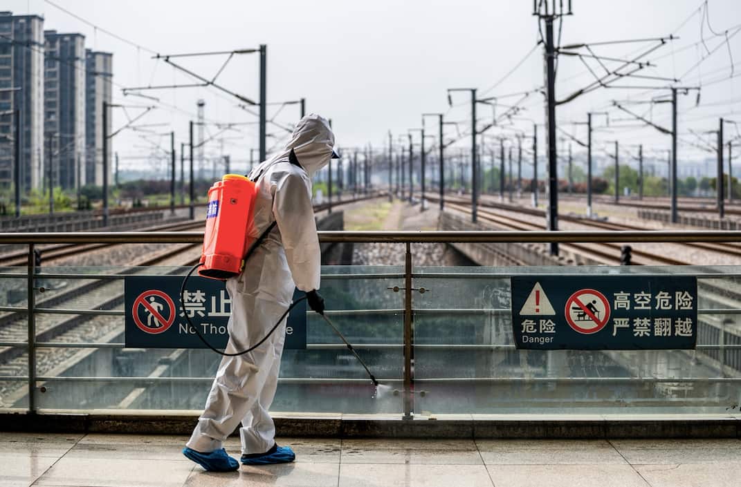 A staff member sprays disinfectant at Wuhan Railway Station.
