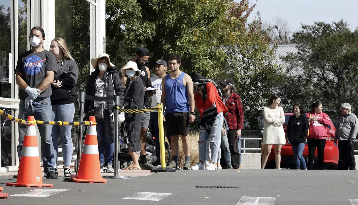 Customers queue to enter a supermarket in Christchurch.