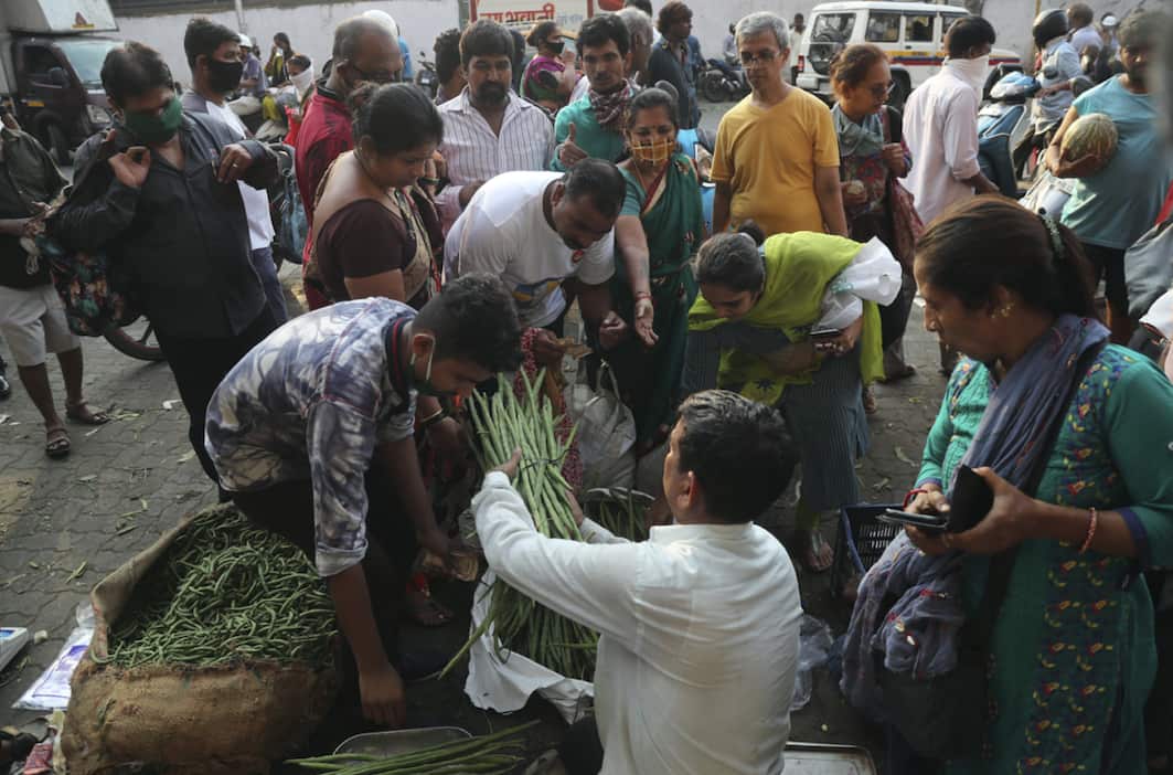 Indians crowd around a vegetable seller in Mumbai.
