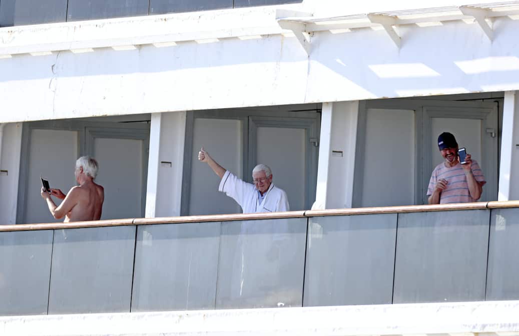 Passengers aboard Holland America's Zaandam cruise ship as it heads into Port Everglades in Fort Lauderdale.