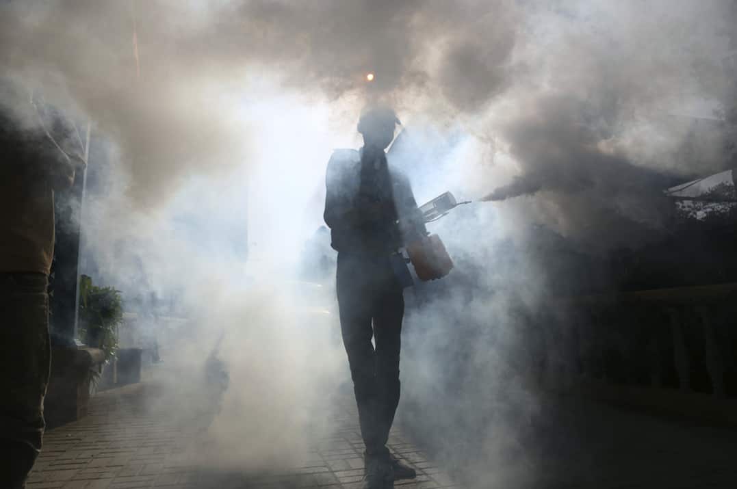 A volunteer disinfects a building in Karachi.