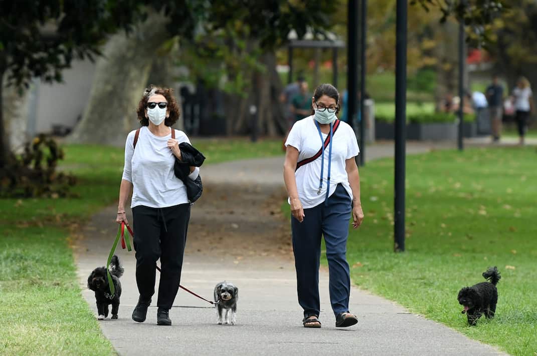 People on a walk through Rushcutters Bay park in Sydney.