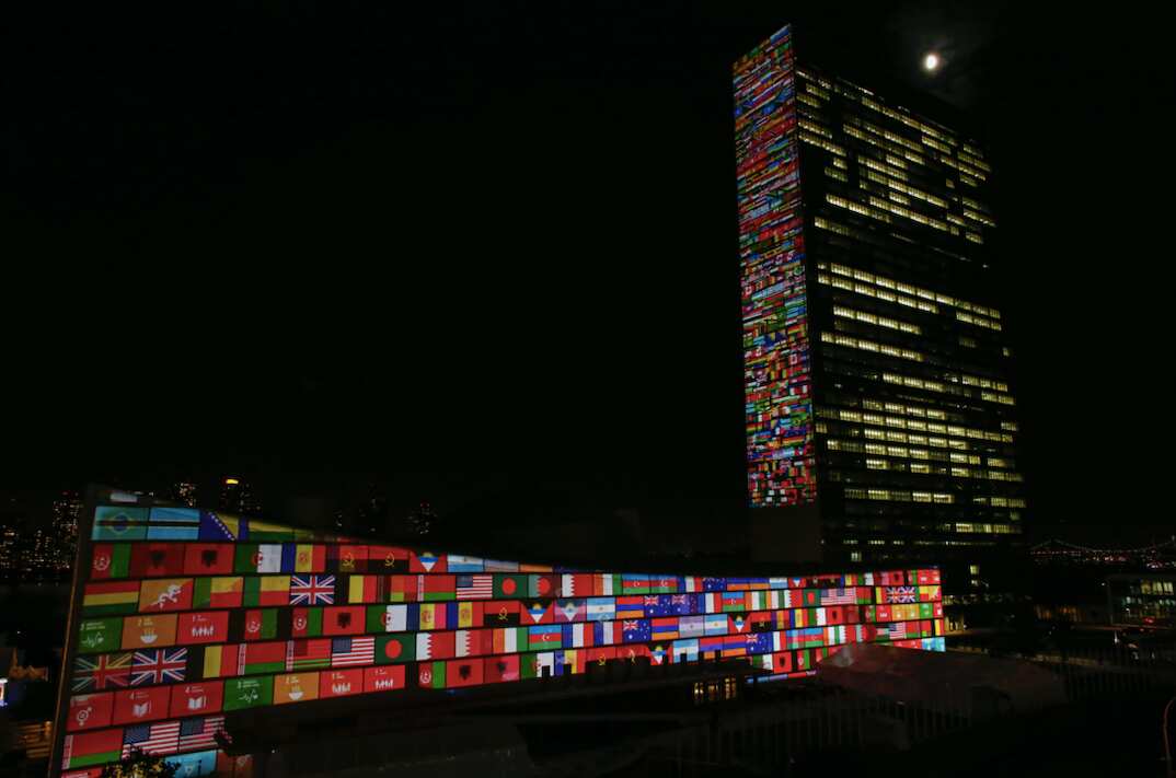 Flags projected on the UN Headquarters building in New York.