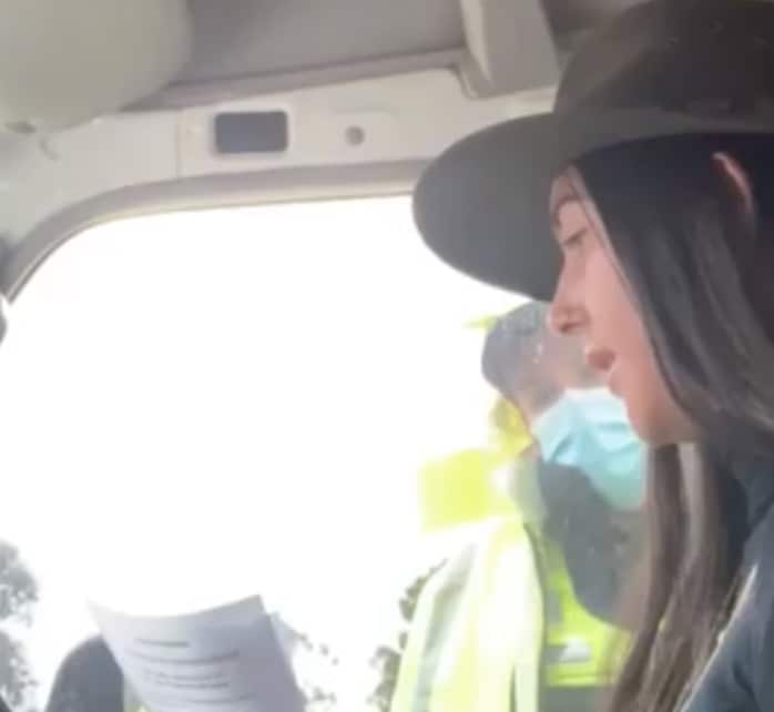 The woman talks to a police officer.