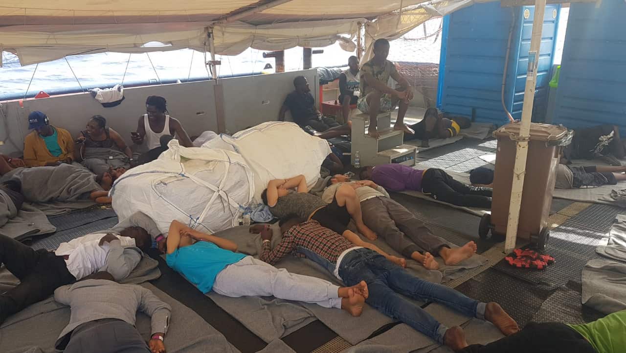 The migrants pictured three days after being rescued from the sea.