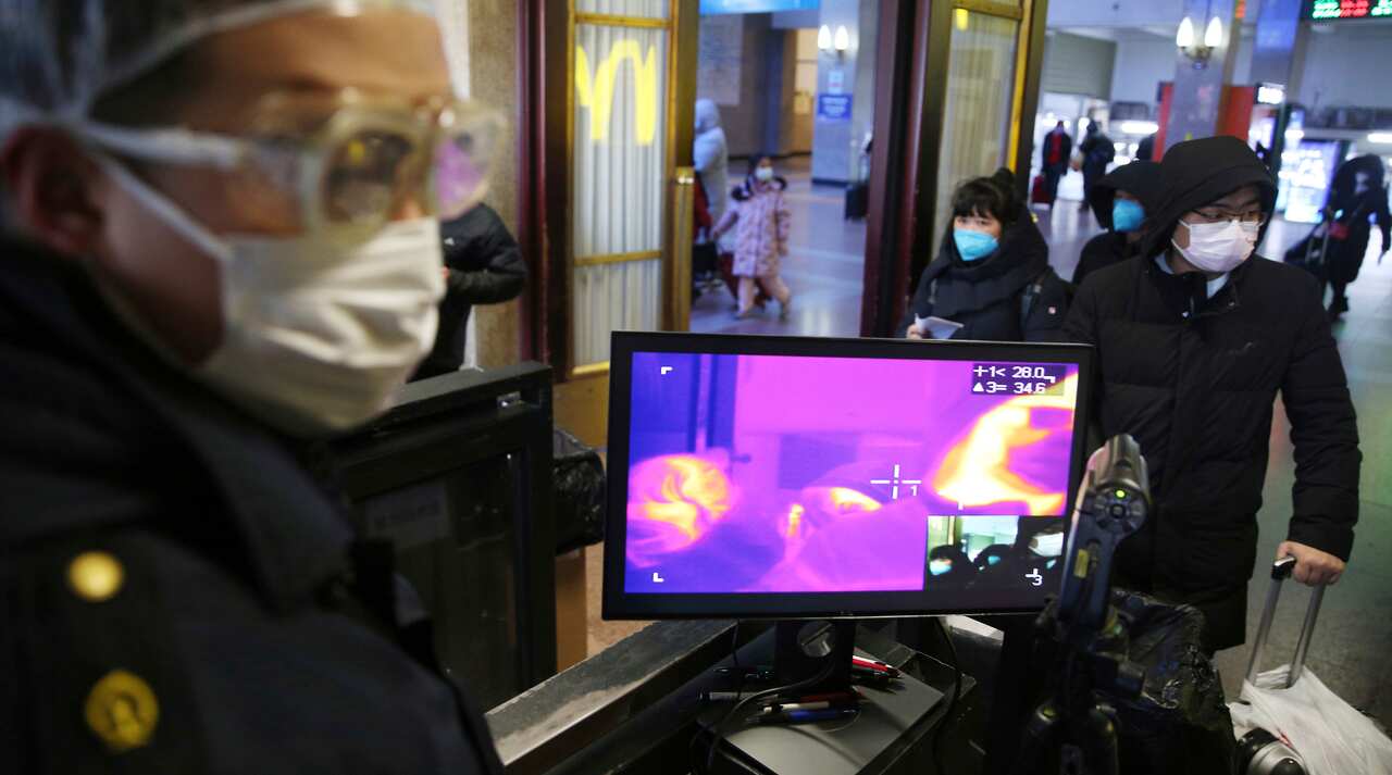 Passengers arriving at the Beijing Station pass for thermography to check a body temperature.