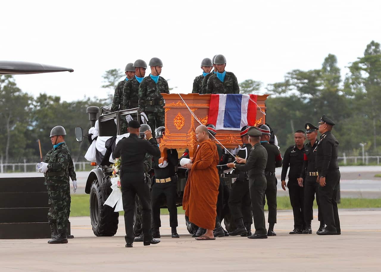 A Thai Buddhist monk leads the guard of honour for the former Seal who died while trying to rescue the "Wild Boars" youth soccer team.