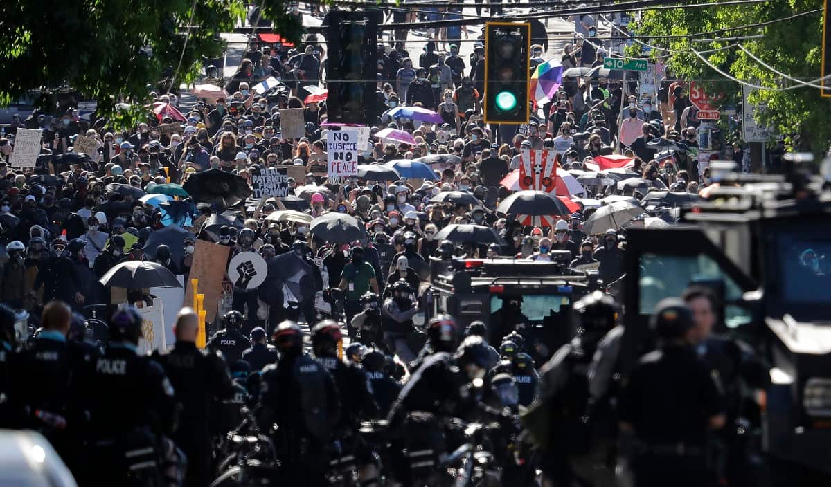 Police clash with protesters, Saturday, July 25, 2020, during a Black Lives Matter protest near the Seattle Police East Precinct headquarters.