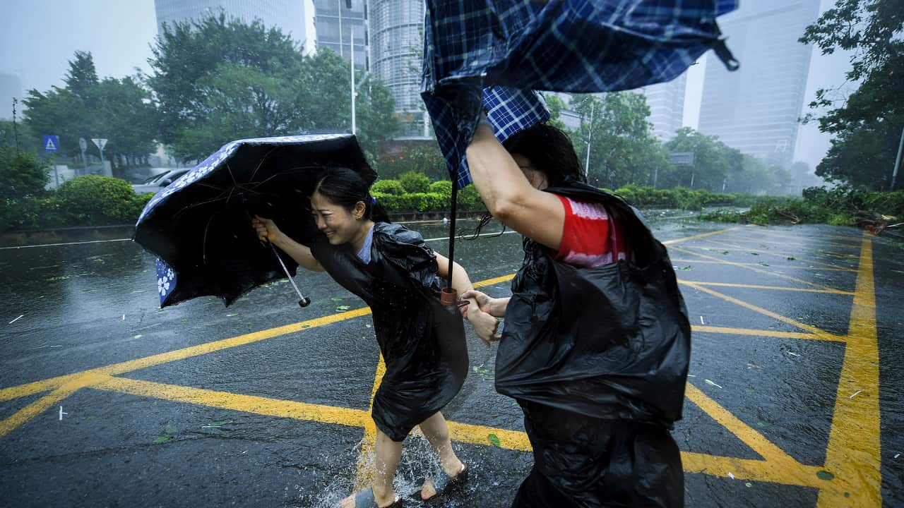 People with umbrellas walk against strong winds from Typhoon Mangkhut at Nanshan District in Shenzhen, south China's Guangdong Province.