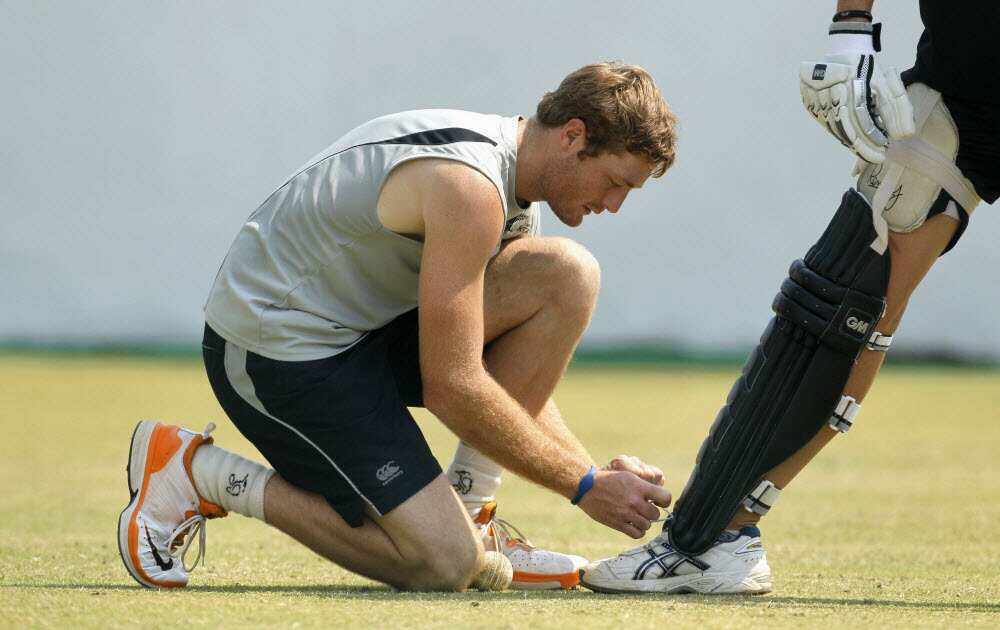 File photo - New Zealand's Martin Guptill ties the shoelaces of a teammate during a training session in Nagpur, India, 2011. 