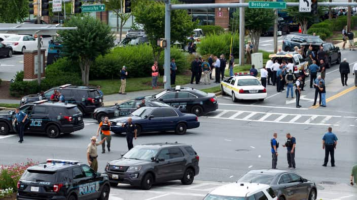 Maryland police officers block the intersection at the building entrance.