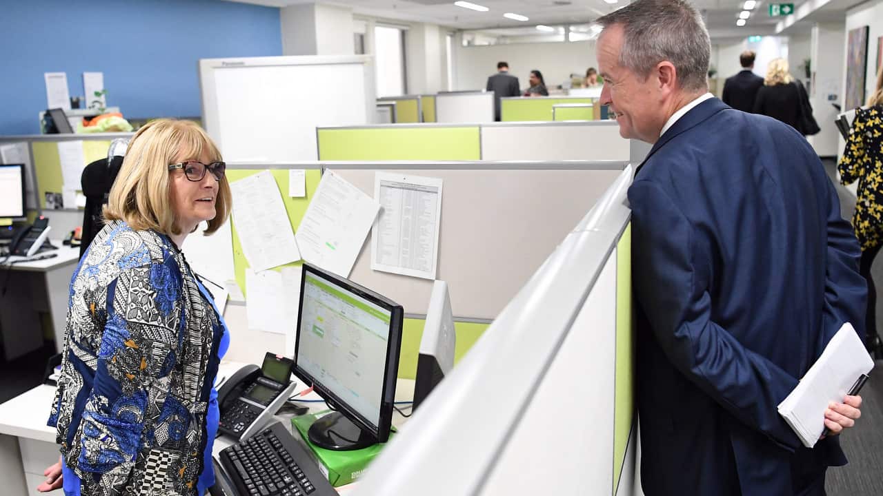 The leader of the Opposition Bill Shorten (right) speaks with staff member Dianne Dejanovic at the Consumer Action Law Centre in Melbourne.