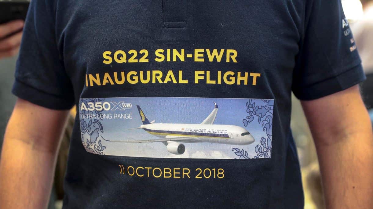 A man wearing a commemorative t-shirt for the flight of Singapore Airlines flight SQ22 at the check-in counter of the Changi Airport in Singapore.