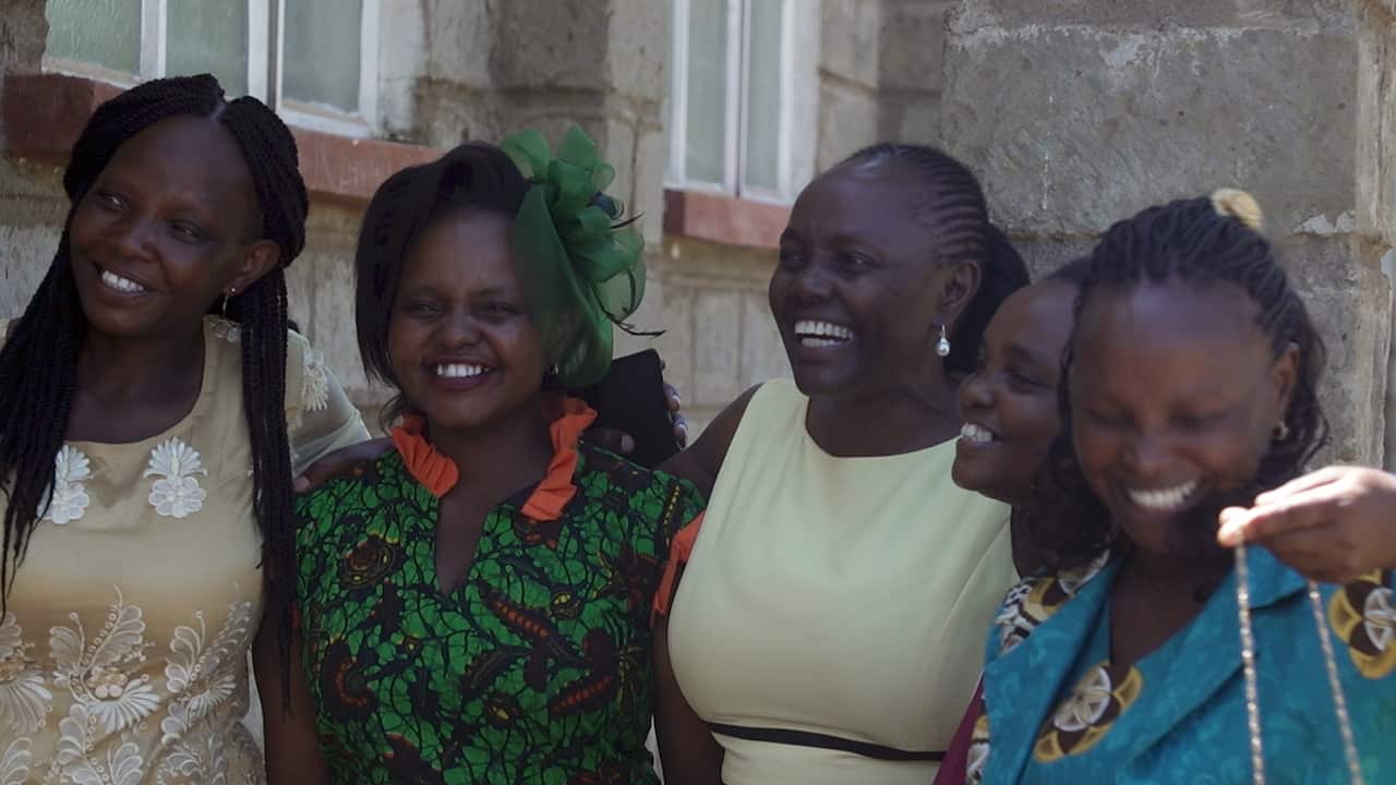 Lucy Gichuhi, centre, with her younger sisters, outside Hiriga Catholic Church in Kenya.