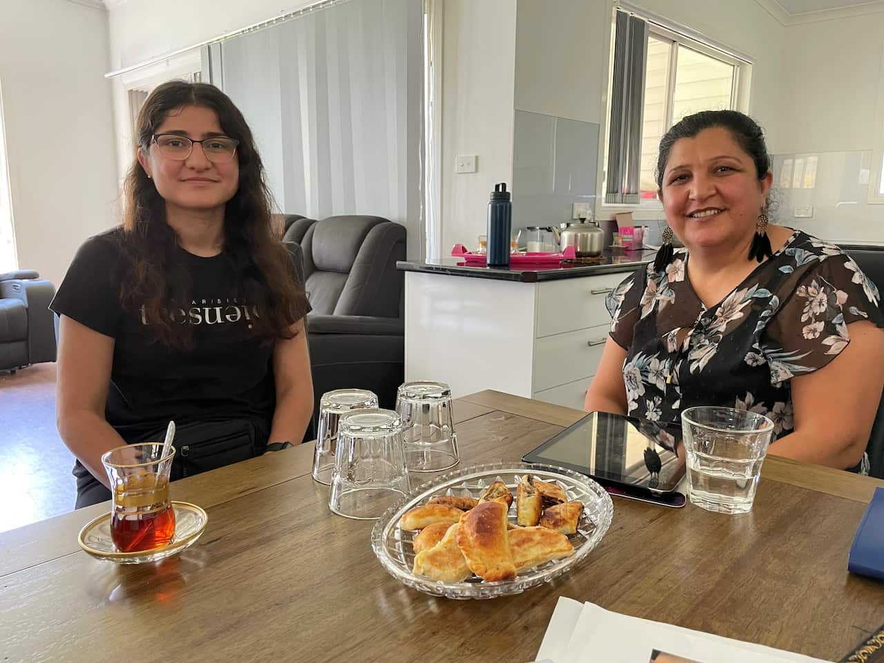 Khishkok Hameed shares tea and home-made sweets with her older sister Sabeeha. 
