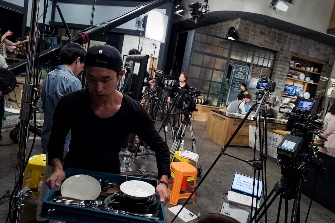 A staff member of The Olive Show puts away plates used in the Sept. 16 studio taping in Seoul.