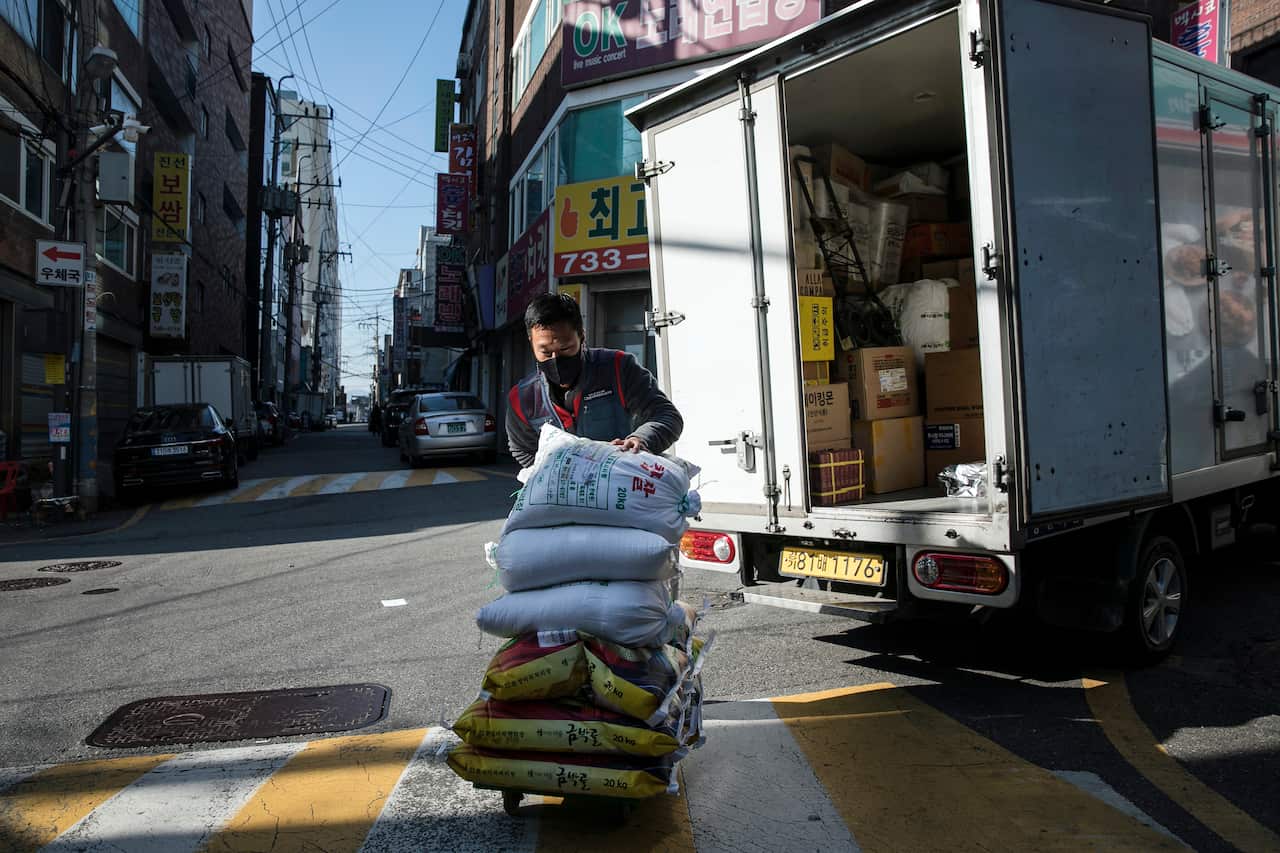 Park Ki-Ryeon, a courier, delivers bags of rice to customers in Seongnam, a city on the outskirts of Seoul, South Korea, 30 November, 2020.