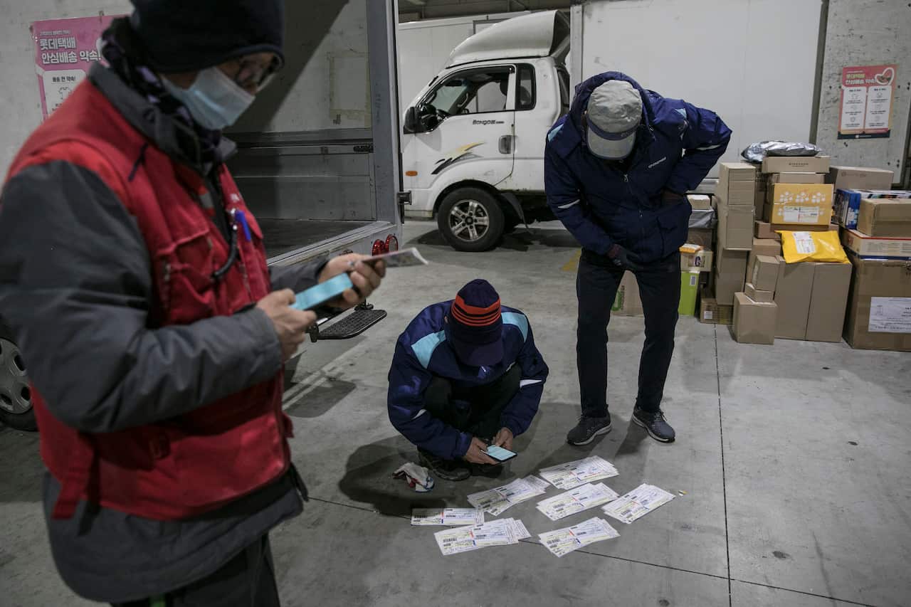Couriers check delivery addresses at a distribution center in Seoul, South Korea, 30 November, 2020.