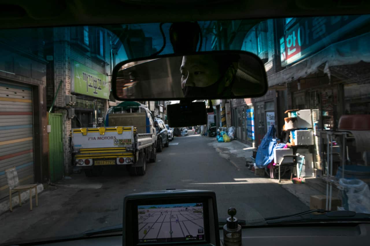 Park Ki-Ryeon, a courier, drives his delivery truck along a narrow street in Seongnam, South Korea, 30 November, 2020
