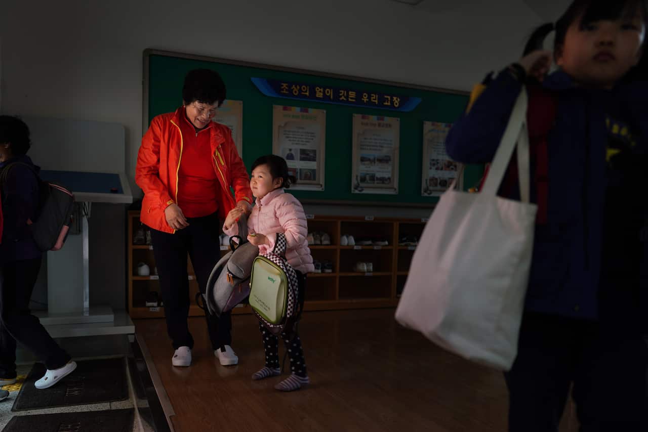 Hwang Wol-geum, 70, and her granddaughter, Soo-hee, arrive for classes at Daegu Elementary, in Gangjin County, South Korea.