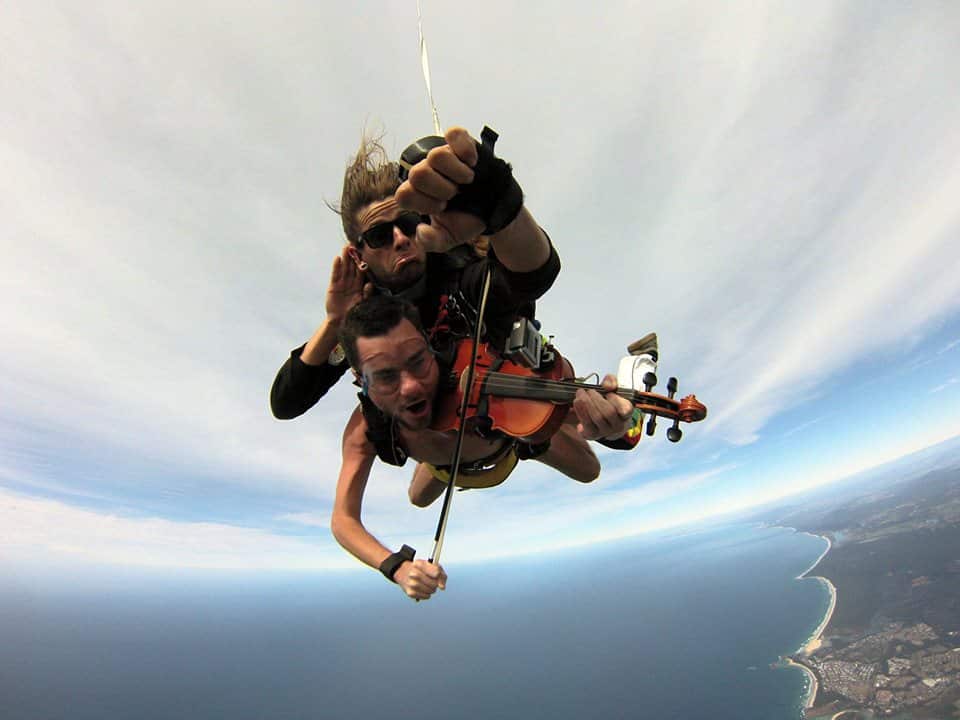 Glen Donnelly playing his violin while falling from a plane to raise money for charity.