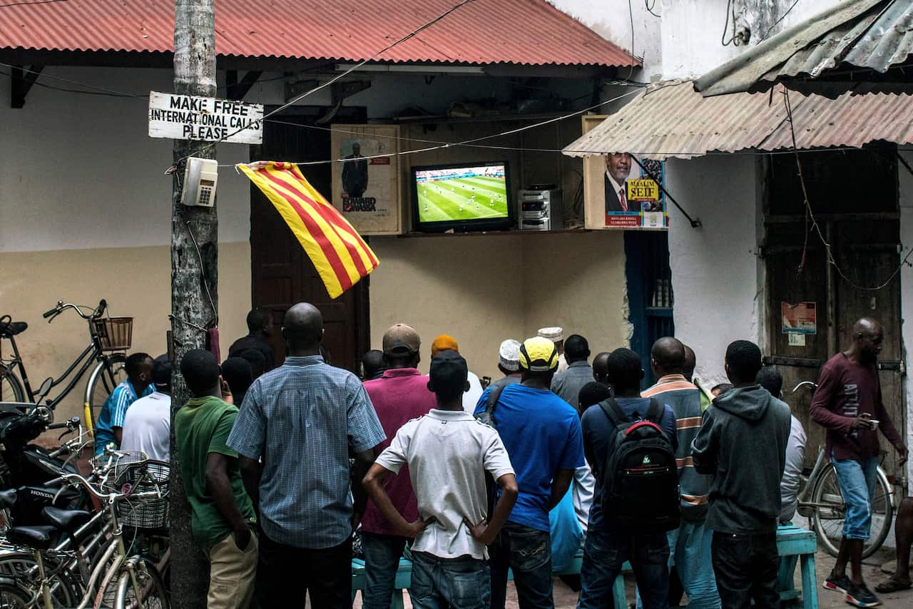 People gather in a public square to watch Germany play Mexico in the World Cup, in Stone Town, Zanzibar.