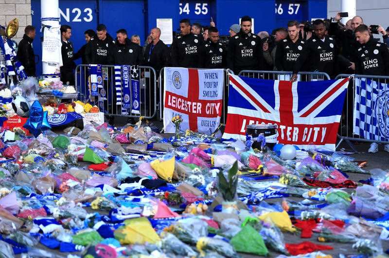 Leicester players pay their respect at the growing shrine outside the stadium.