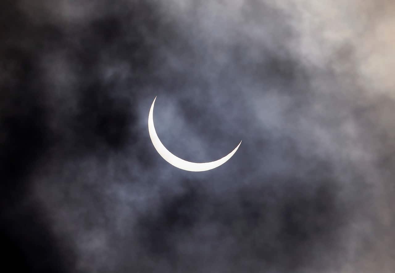 The sun is seen through rain clouds during solar eclipse in New Delhi, India on 21 June 2020. 