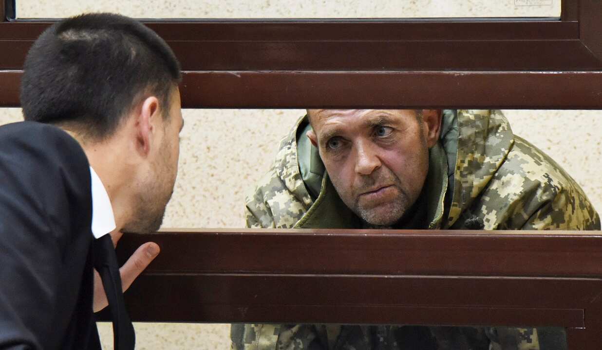 One of the captured Ukrainian sailors speaks with his lawyer in a court room in Simferopol, Crimea.