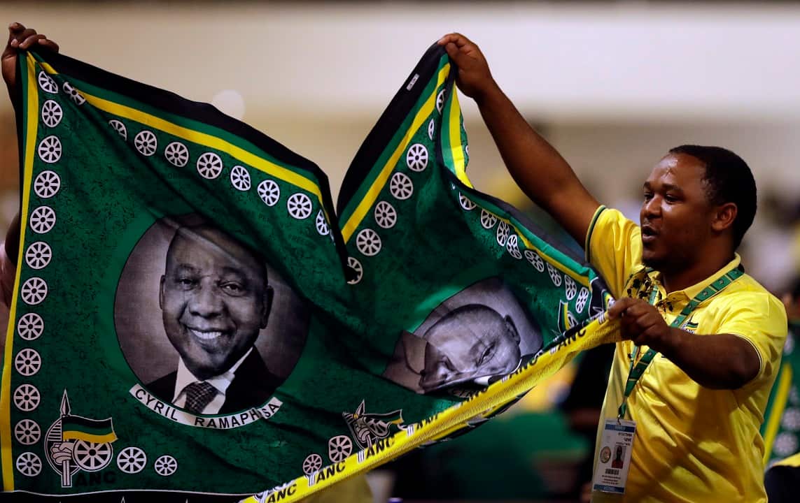 An ANC supporter holds party paraphernalia with the face of the new African National Congress President, Cyril Ramaphosa.