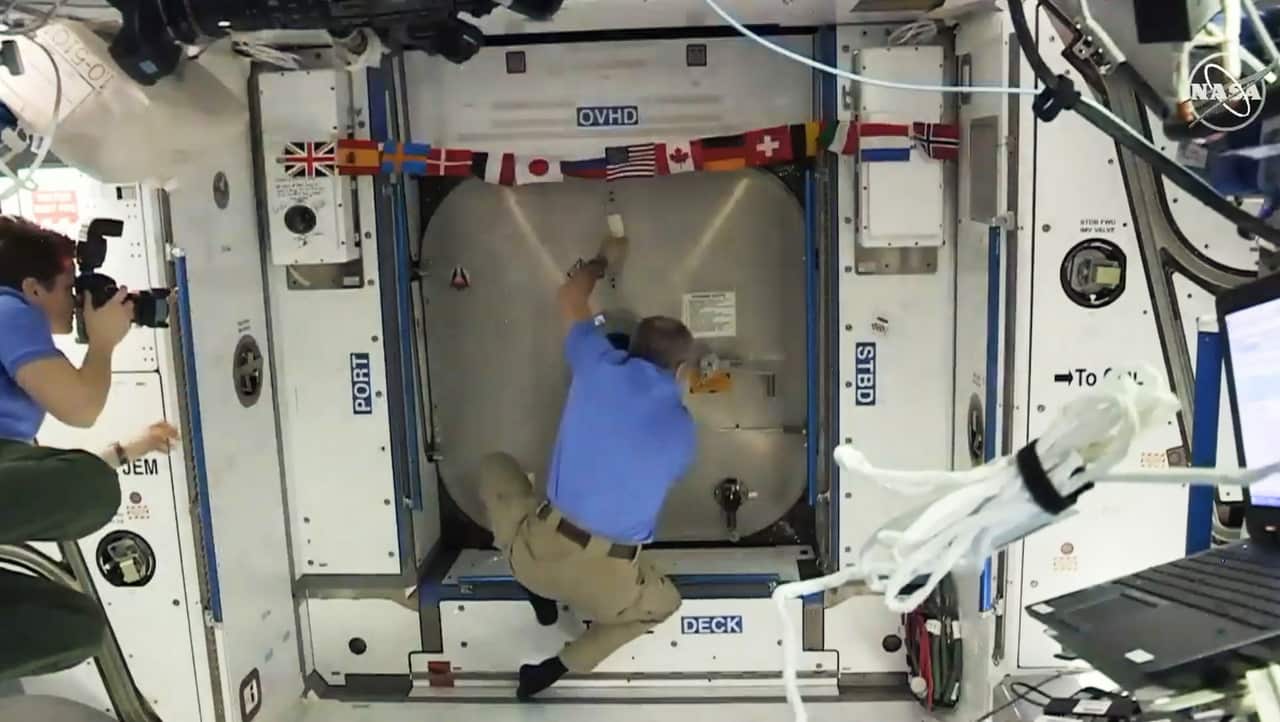 Astronauts aboard the Space Station prepare to open hatchet to the SpaceX Dragon capsule carrying a instrumented dummy.